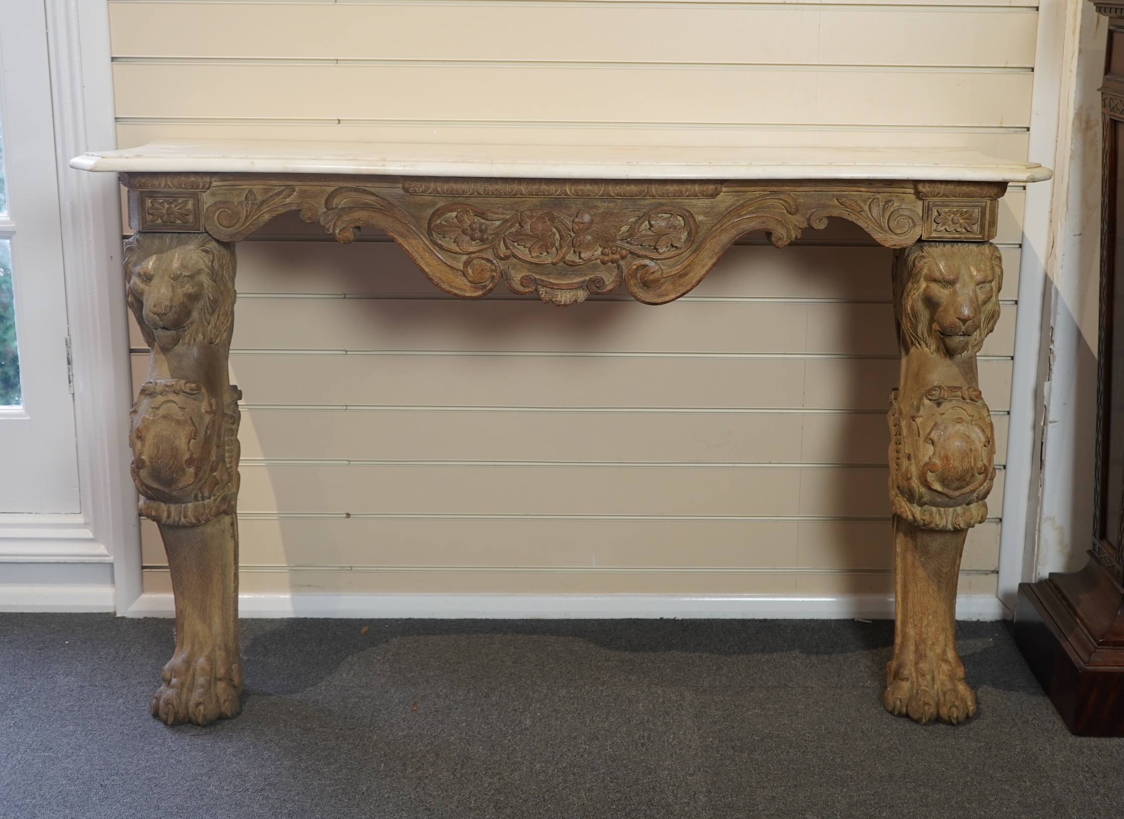 A 19th century Baroque style marble topped limed oak serpentine console table
